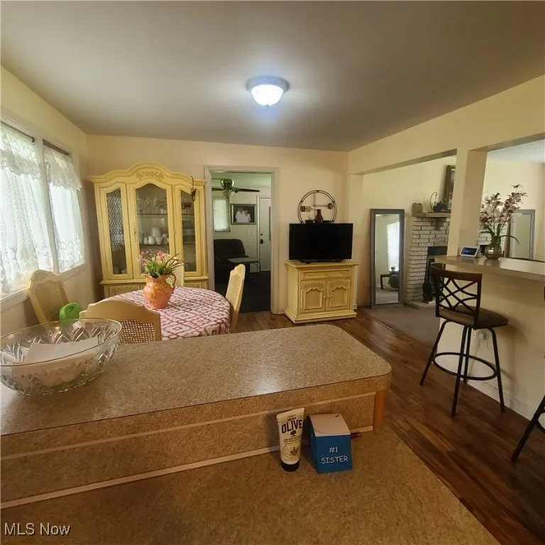 View from Kitchen of Dining area with wood-type flooring and entries to the Living room and family room