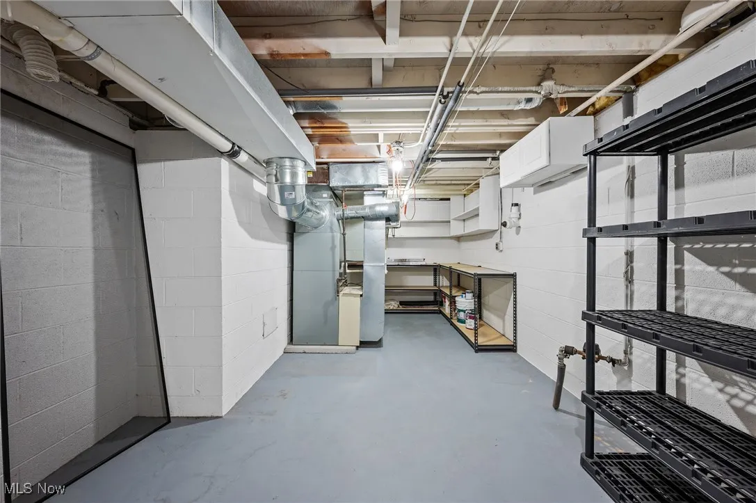 Unfinished basement with heating unit and concrete block wall