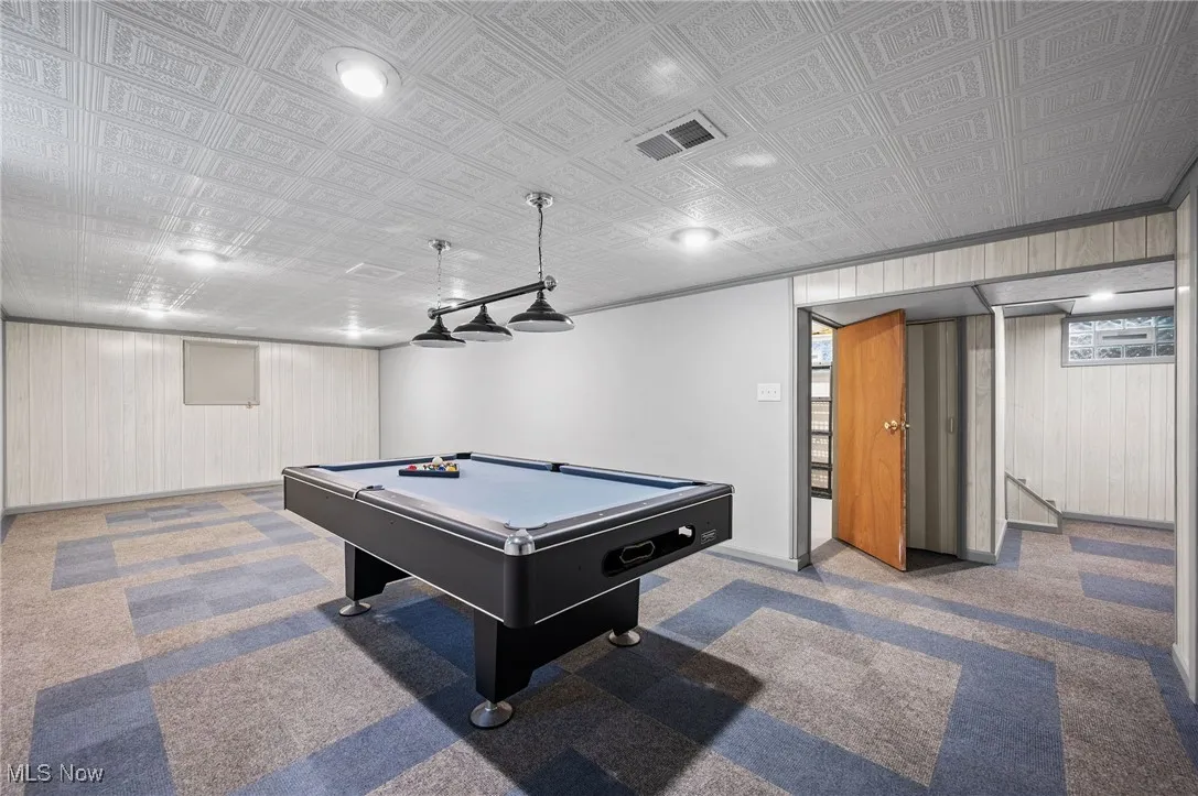 Game room with carpet flooring, billiards table, and wooden walls