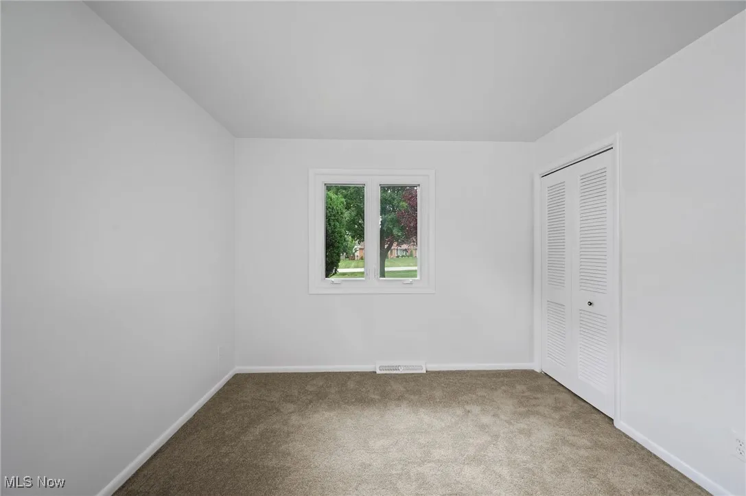Unfurnished bedroom featuring carpet and a closet