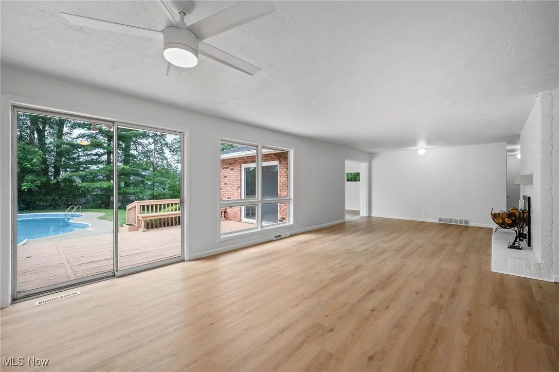 Unfurnished living room featuring a textured ceiling, wood finished floors, and ceiling fan