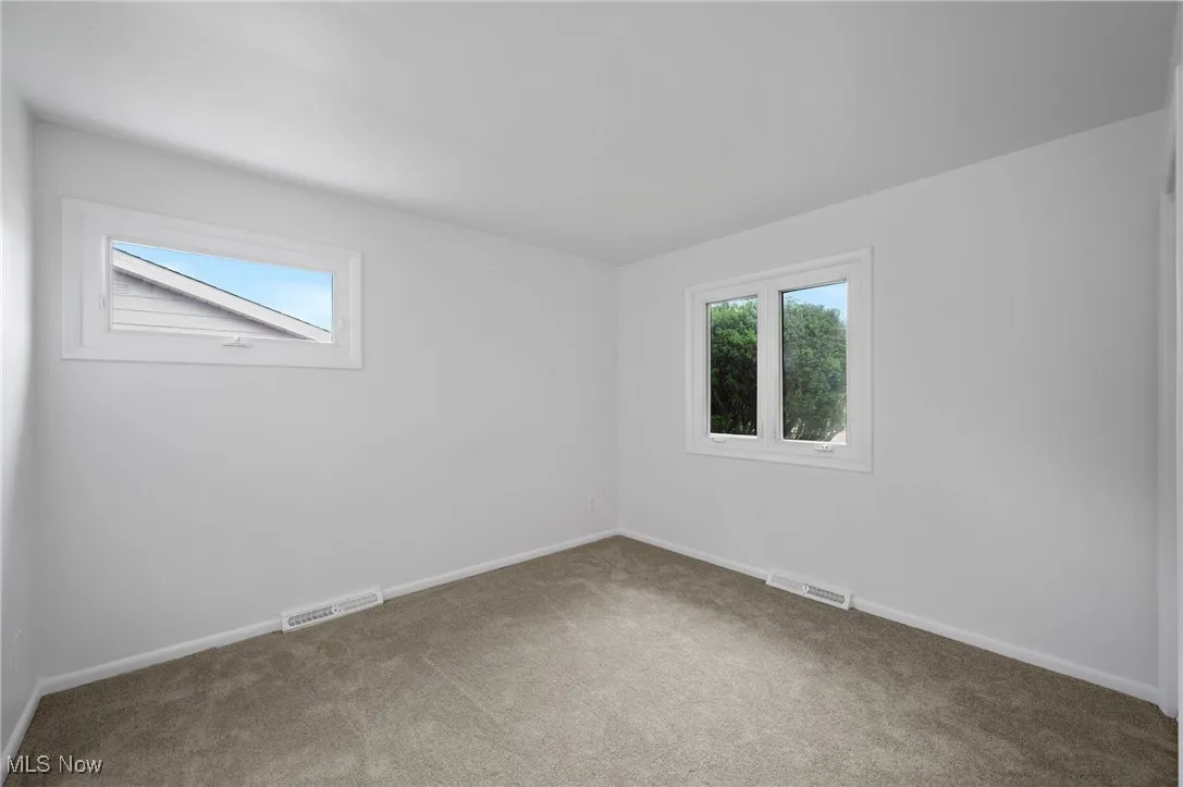 Carpeted spare room with baseboards