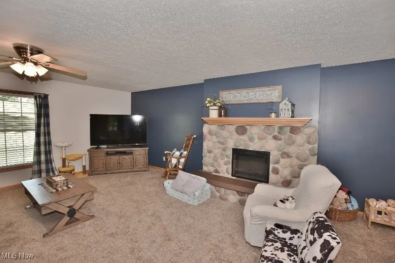 The spacious living room features and stone fireplace with a electric fireplace insert.