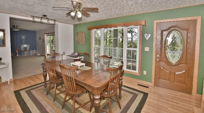 The dining area features a beautiful windows and an entry door leading to the front deck.