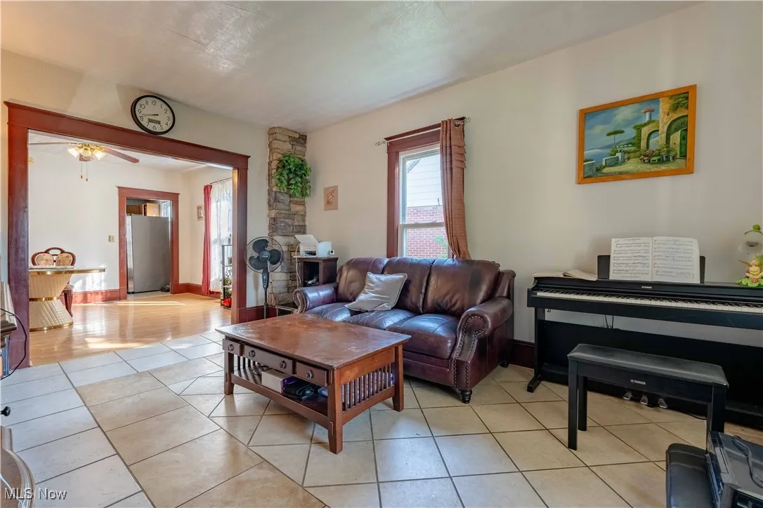 Living area with light tile patterned floors and a ceiling fan
