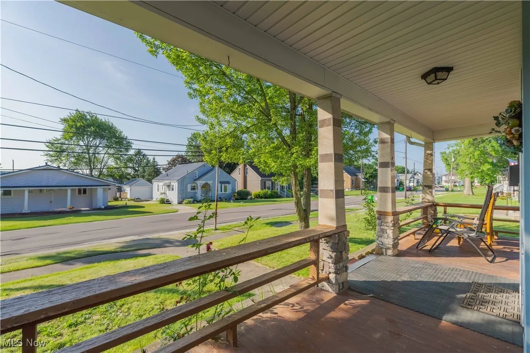 Covered porch with a residential view and a lawn