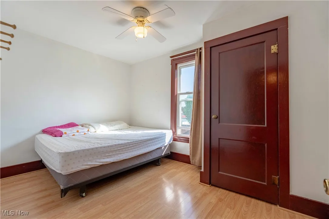 Bedroom with light wood finished floors and a ceiling fan