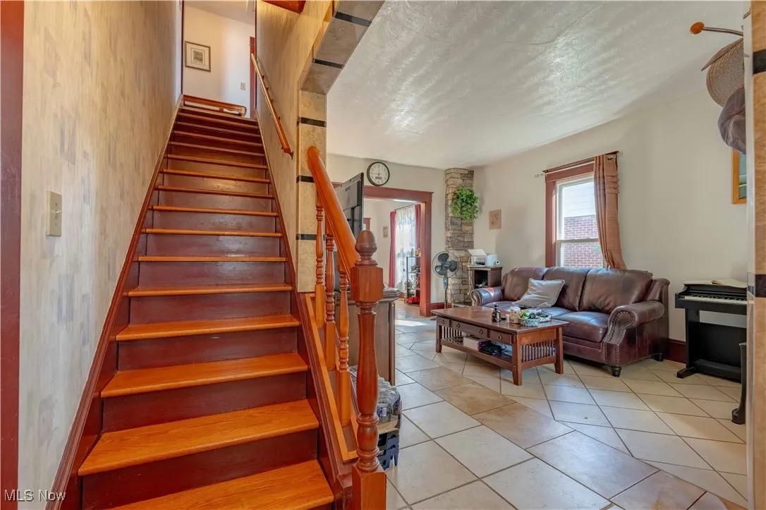 Stairway featuring a textured ceiling and tile patterned floors