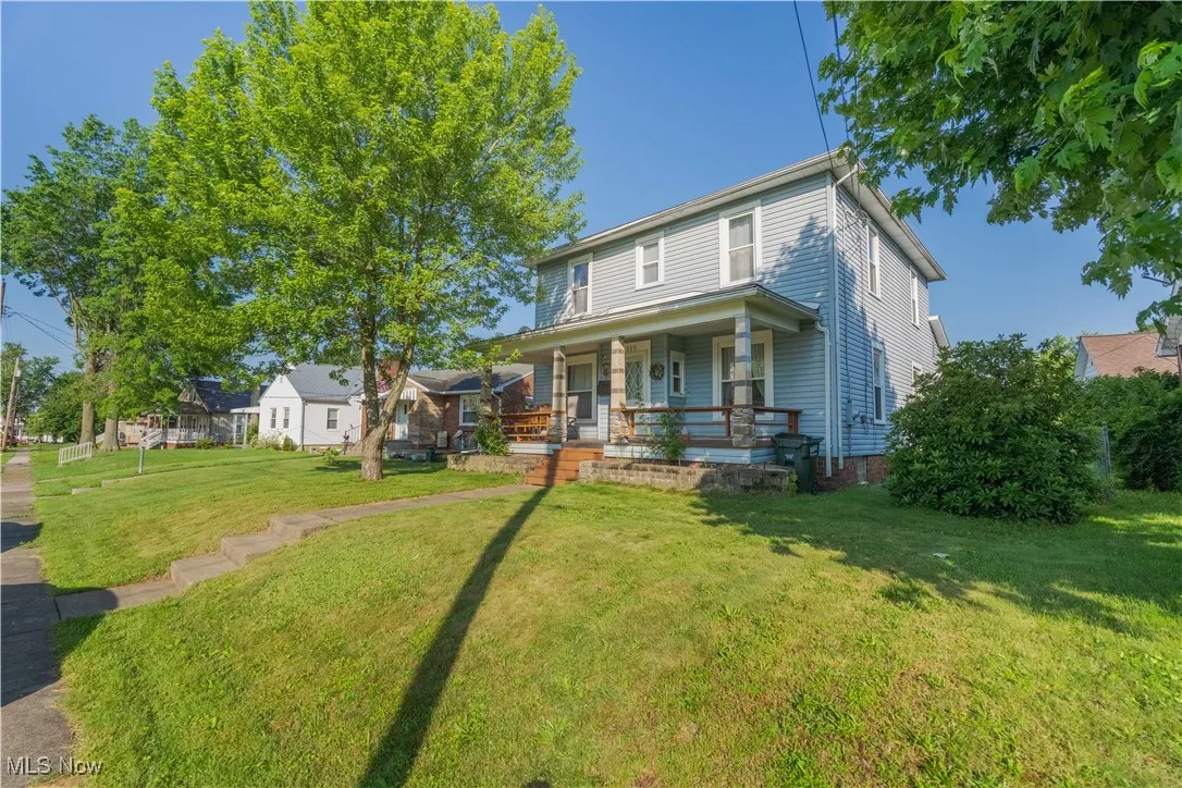 View of front of property with a porch and a front lawn
