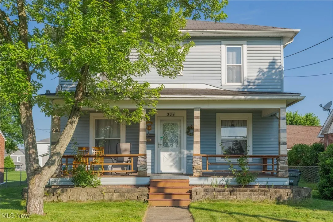 American foursquare style home featuring covered porch