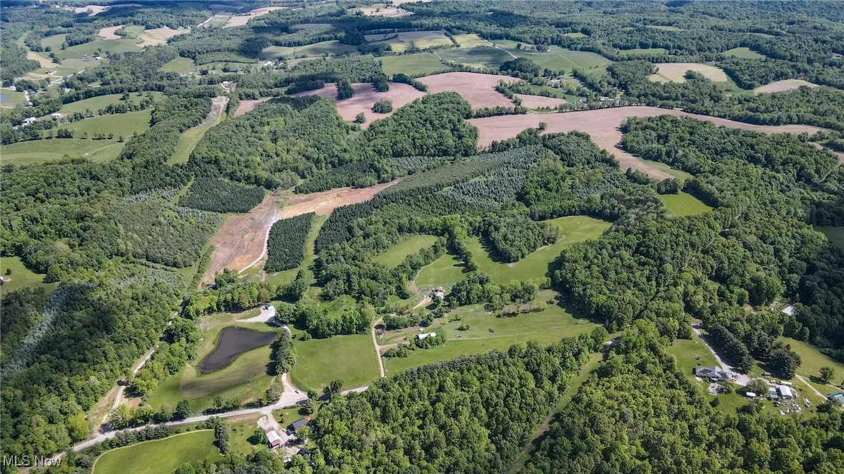 Aerial view of property and surrounding area featuring a heavily wooded area