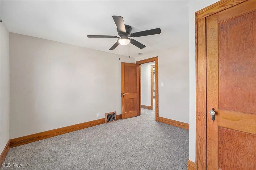 Unfurnished bedroom with carpet flooring and a ceiling fan