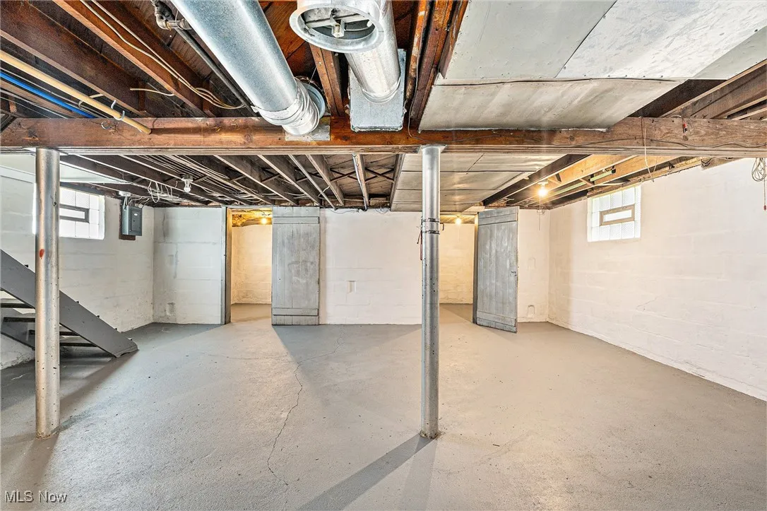 Basement featuring electric panel and stairs