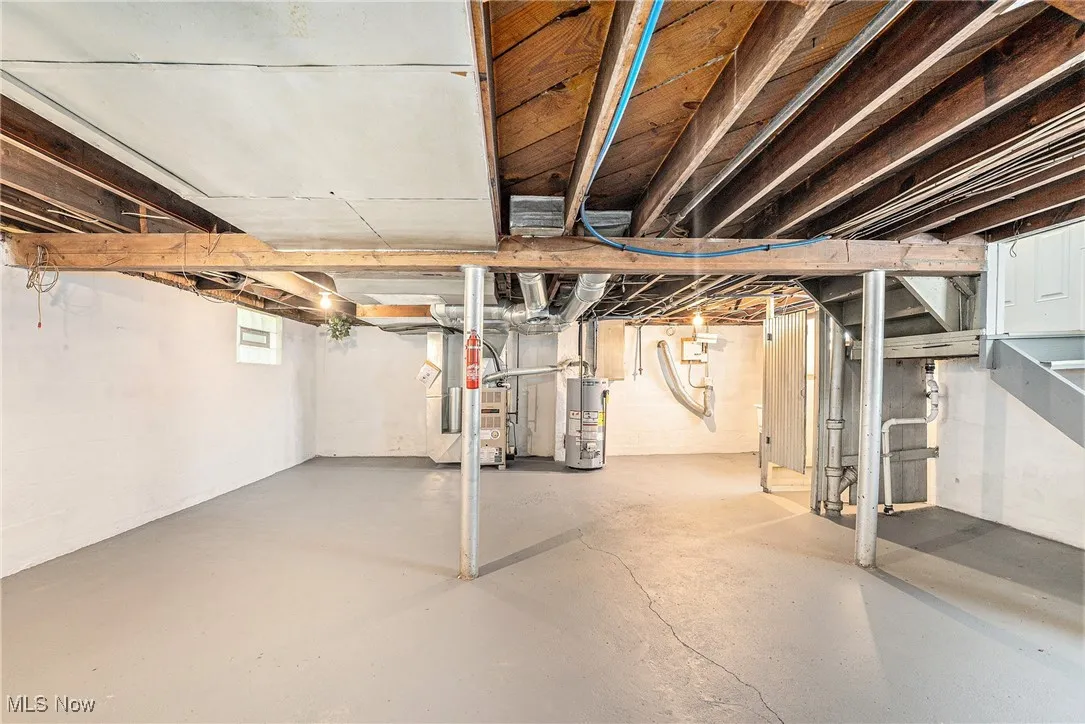 Basement featuring water heater and heating unit