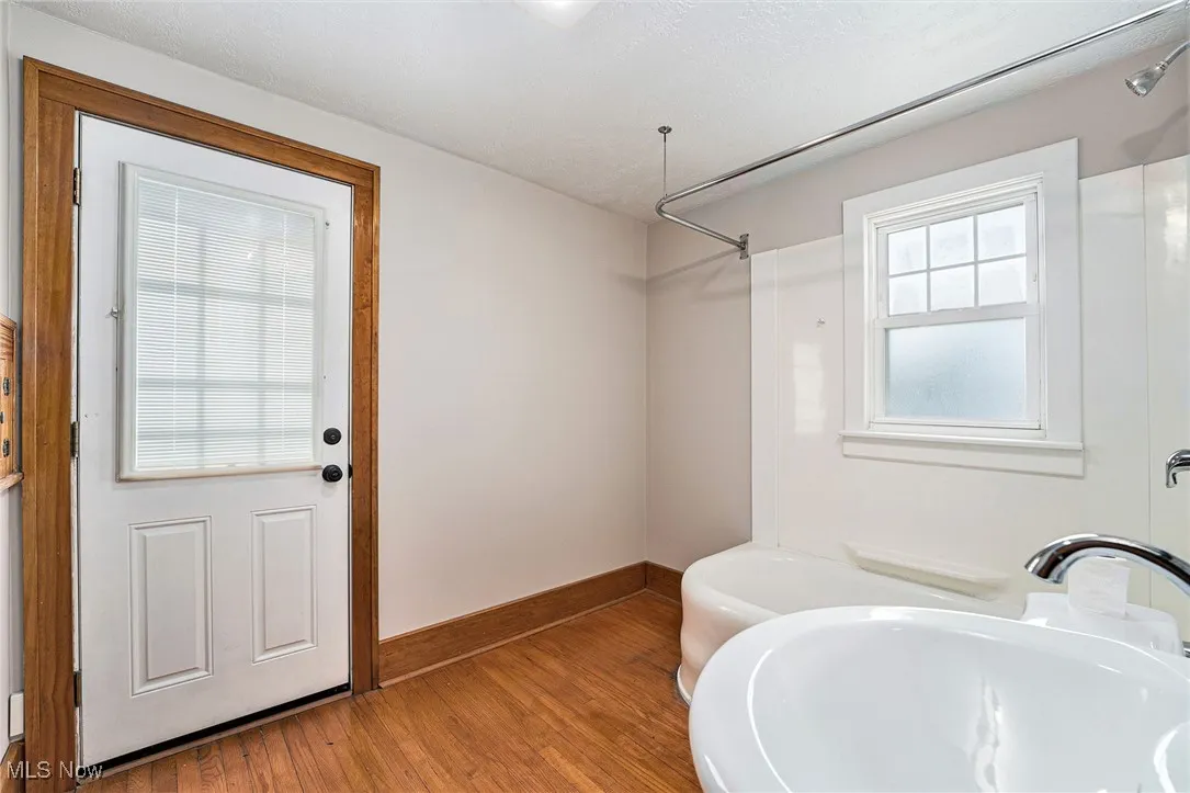 Bathroom featuring wood finished floors and shower / bathtub combination