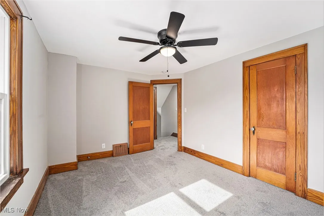 Unfurnished room with carpet floors and a ceiling fan