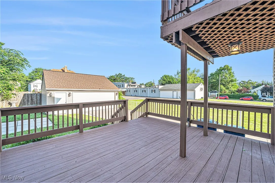 Deck with an outdoor structure, a yard, and a residential view
