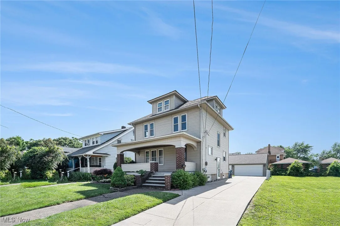 Traditional style home with a porch, a front lawn, and a garage