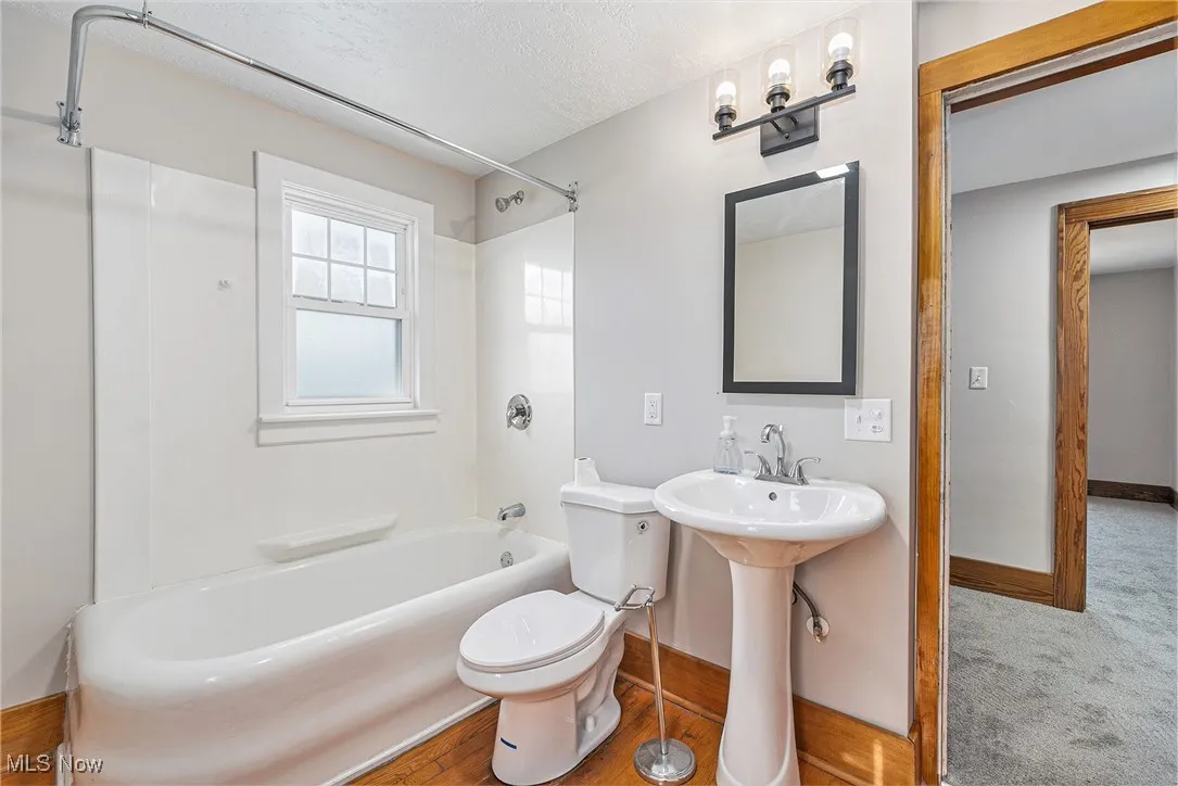 Full bathroom with  shower combination and a textured ceiling