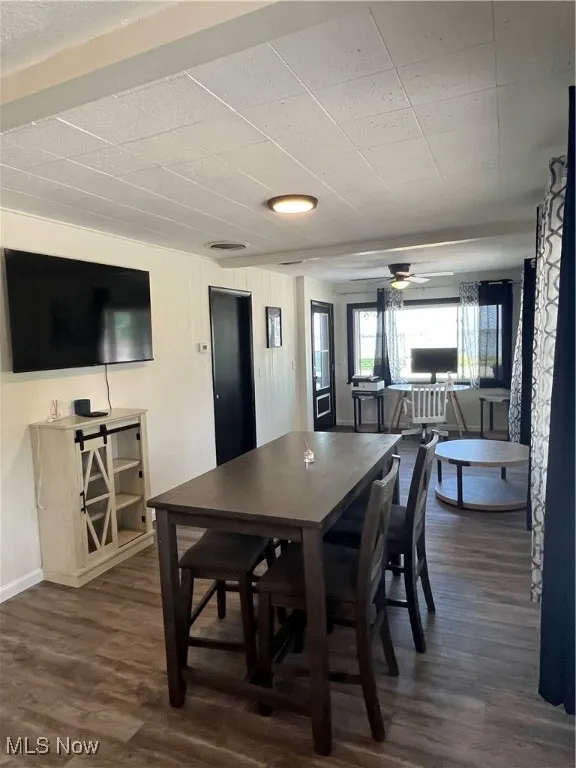 Dining area with dark wood-style floors and a ceiling fan