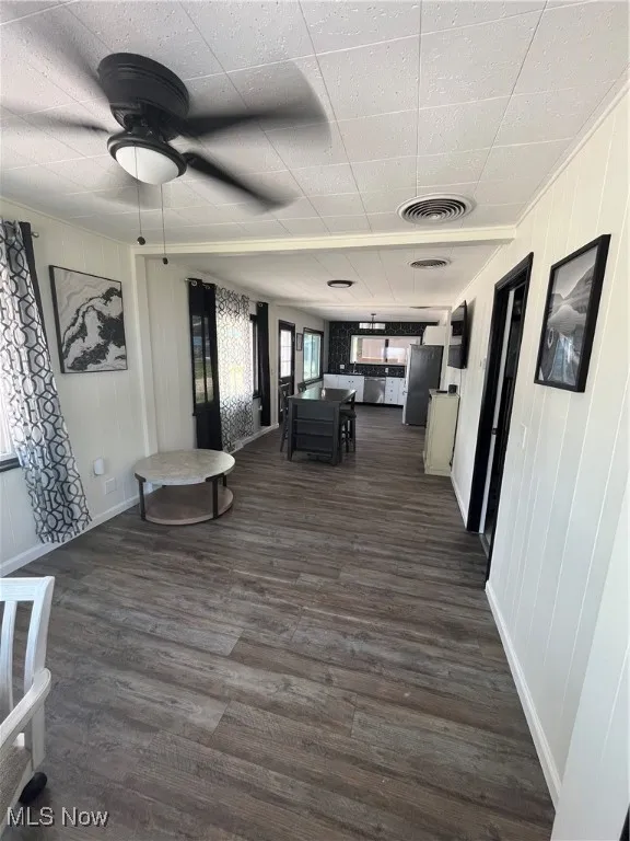 Corridor featuring dark wood-type flooring and crown molding