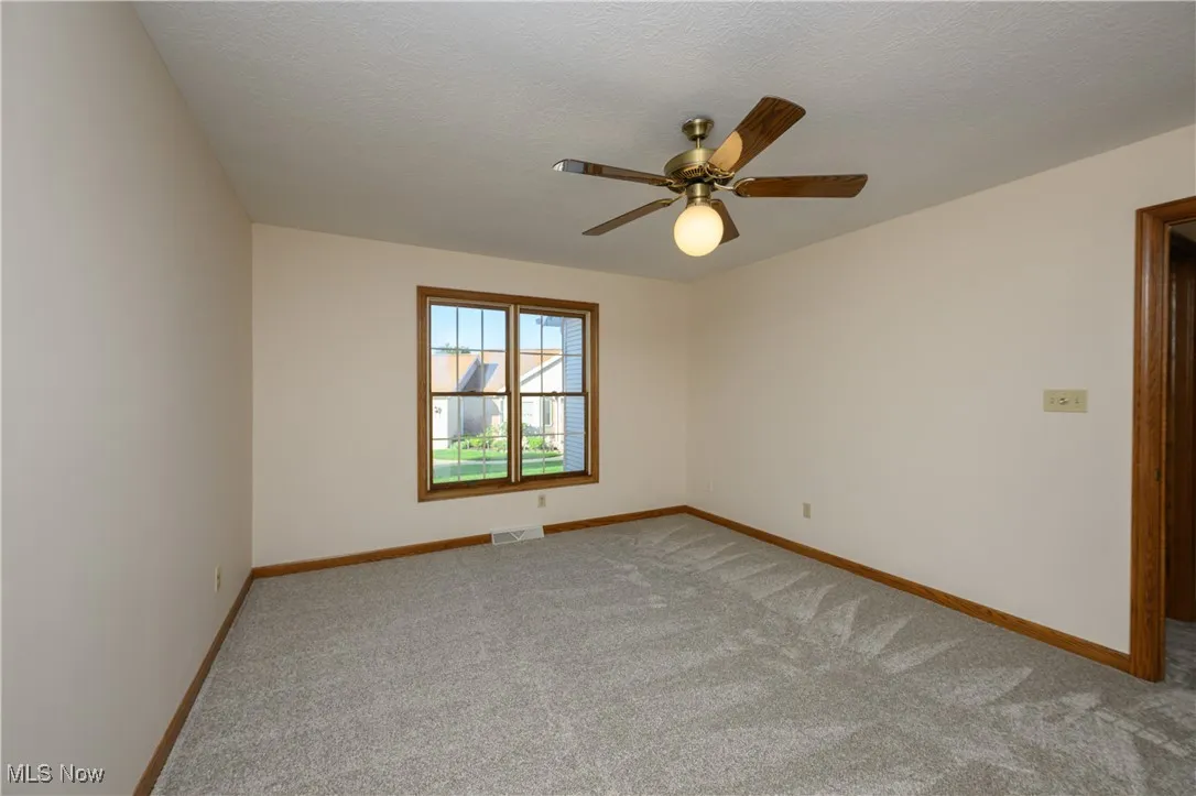 Spare room with light colored carpet and ceiling fan
