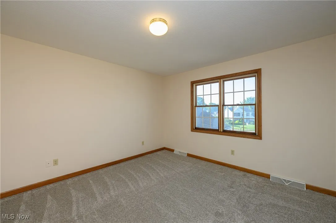Empty room featuring baseboards and carpet floors