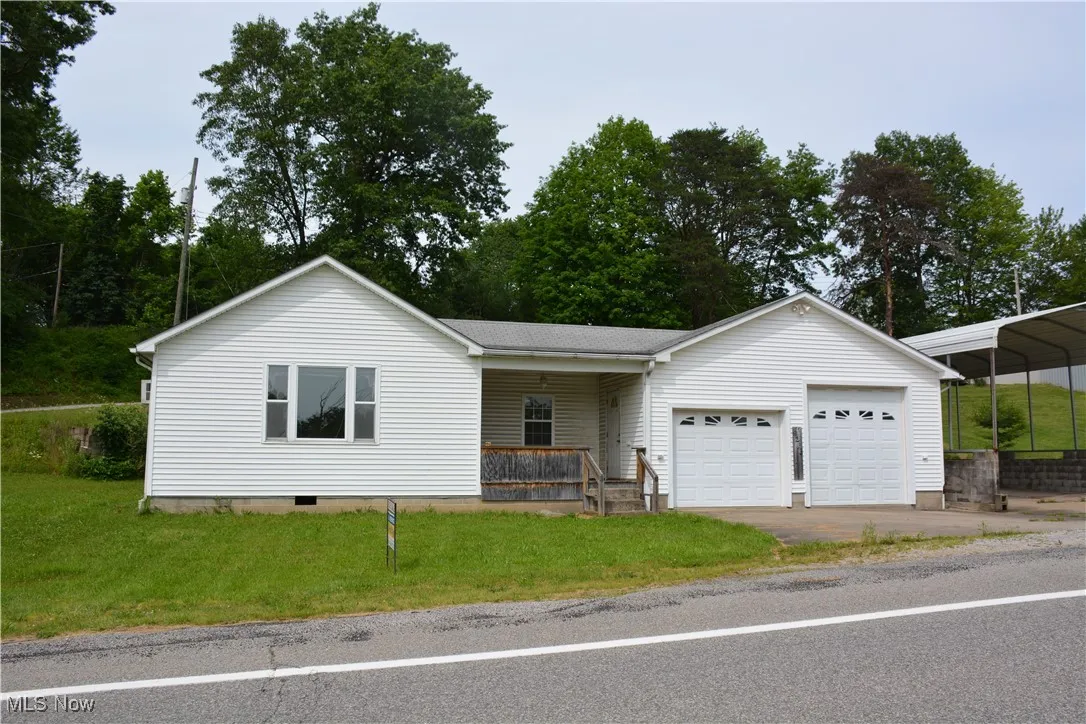 Ranch-style house with a porch, a front lawn, an attached garage, and driveway