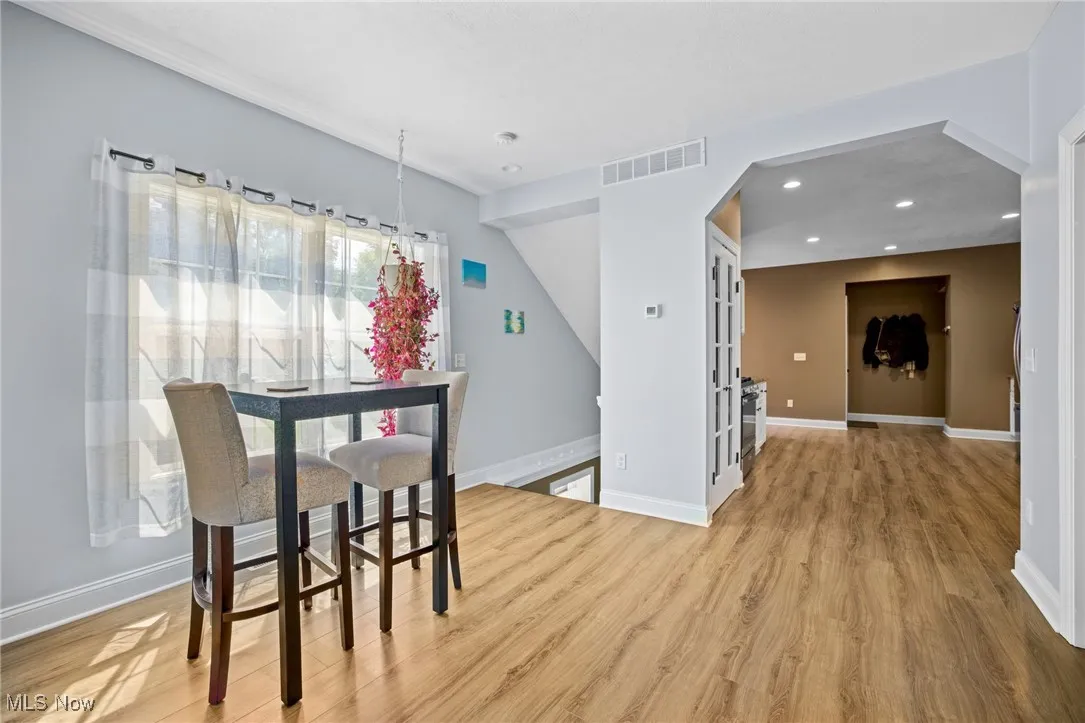 Dining area featuring wood finished floors, recessed lighting, and arched walkways
