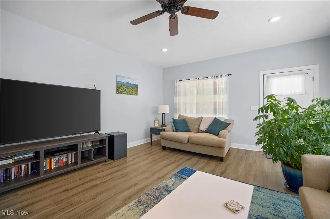 Living room with wood finished floors, recessed lighting, and ceiling fan