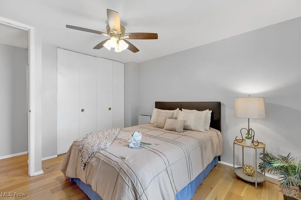 Bedroom with light wood-style floors, a closet, and ceiling fan