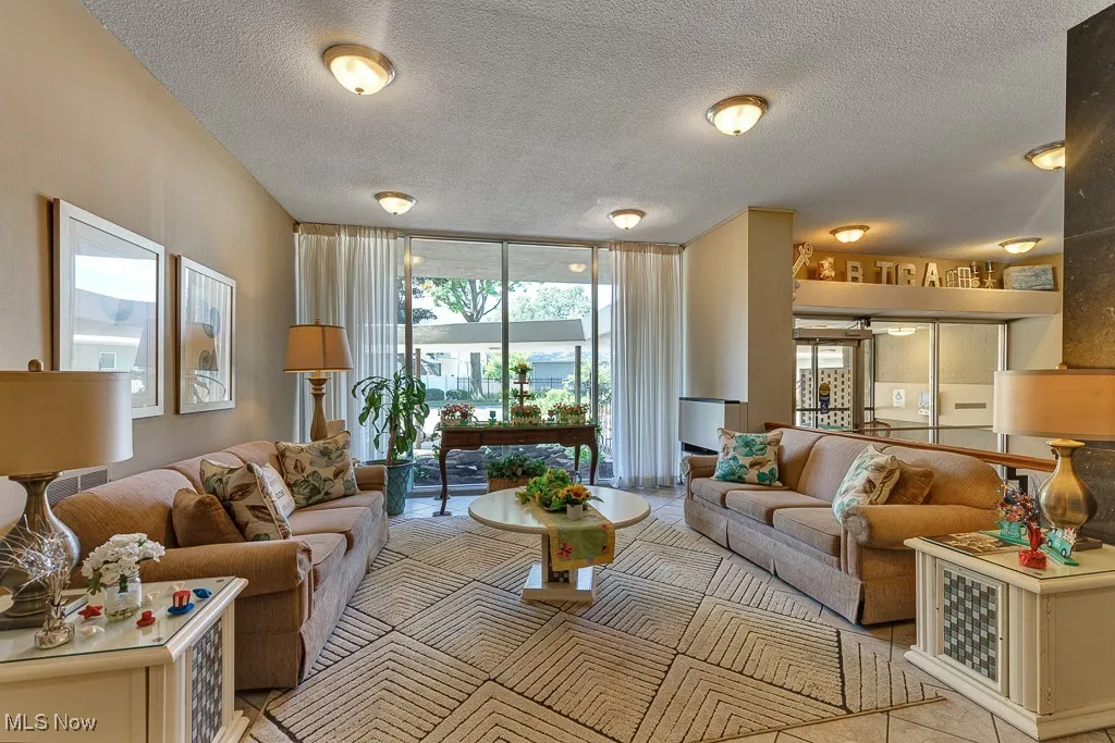 Living room featuring a textured ceiling and a wall of windows
