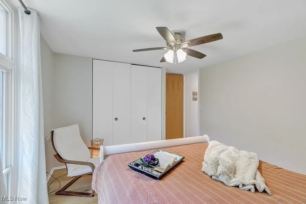 Bedroom with a closet, wood finished floors, and ceiling fan