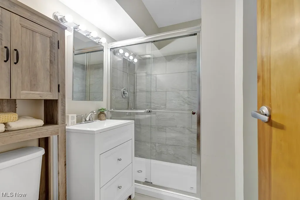 Full bath with a stall shower and vanity