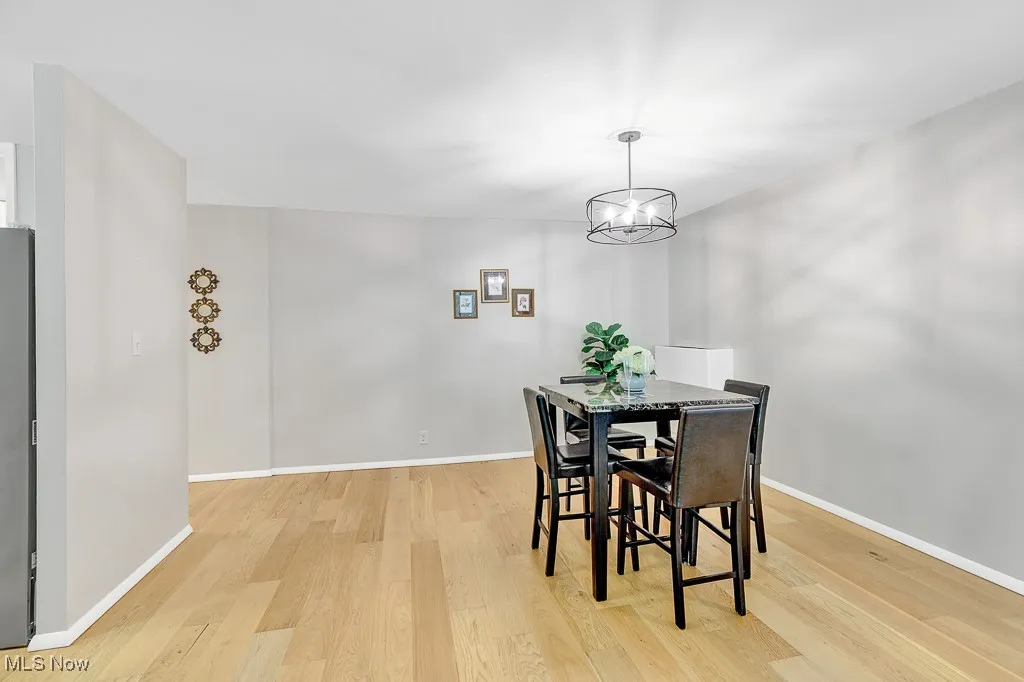 Dining area with light wood-type flooring and a chandelier