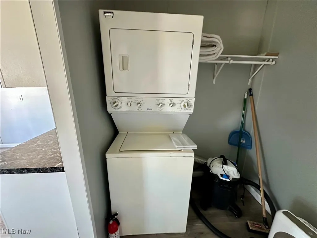 Washroom featuring stacked washer / dryer and wood finished floors