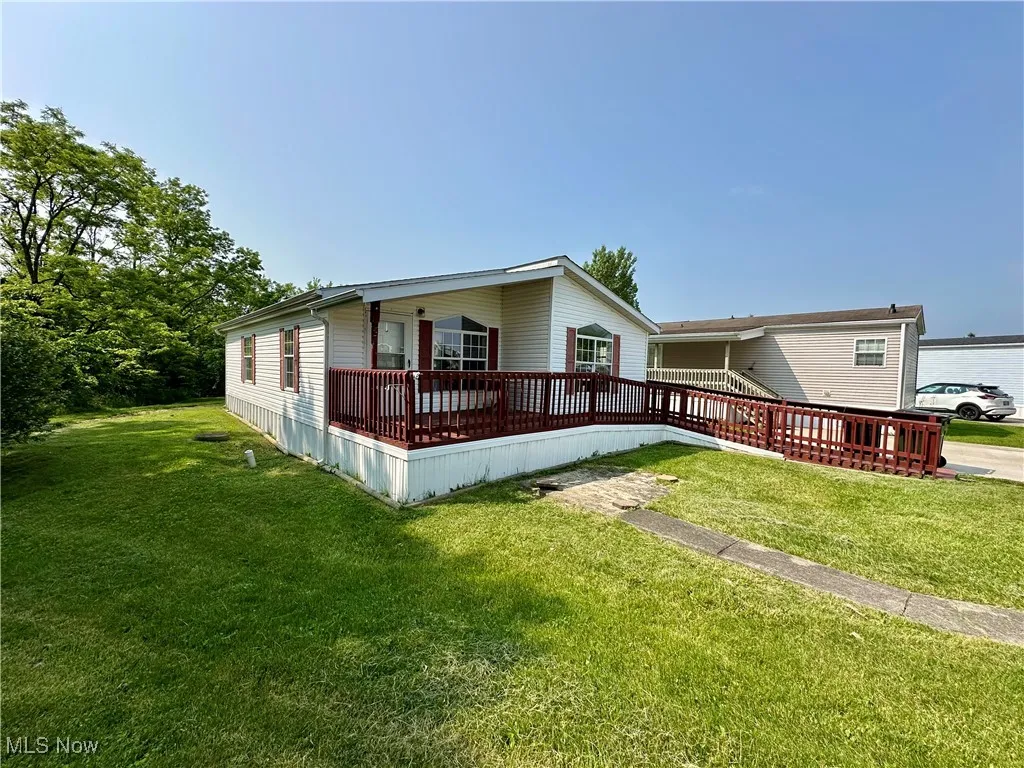 View of front of house with a front lawn and a deck