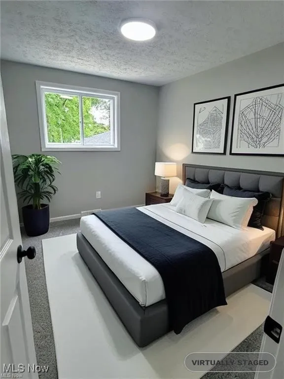 Bedroom featuring a textured ceiling and carpet