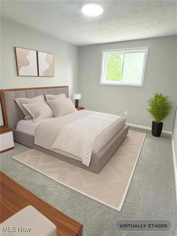 Bedroom featuring carpet floors and a textured ceiling