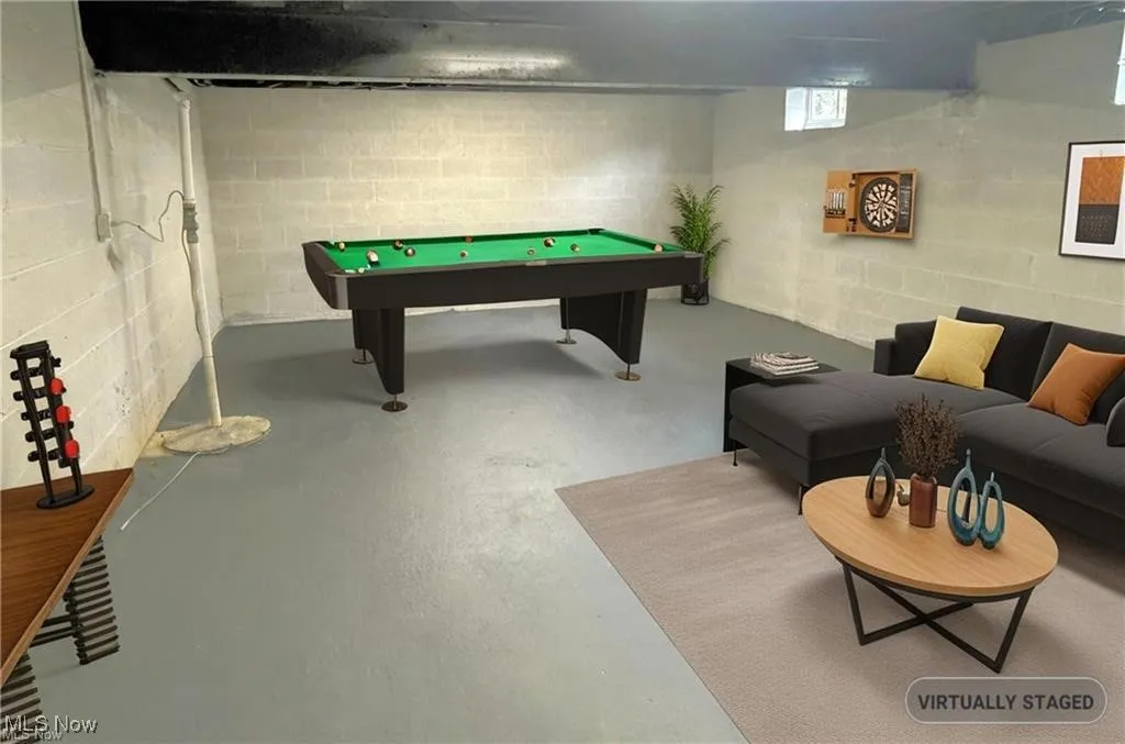 Rec room featuring concrete flooring, billiards table, and concrete block wall