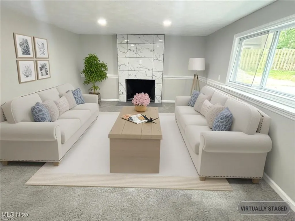 Carpeted living room with a fireplace and baseboards