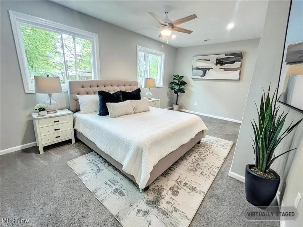 Carpeted bedroom with baseboards and a ceiling fan
