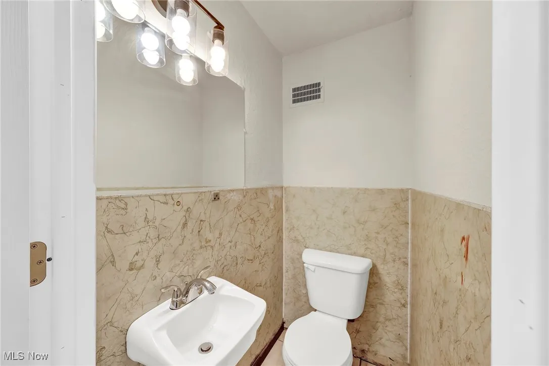 Bathroom with tile walls and wainscoting