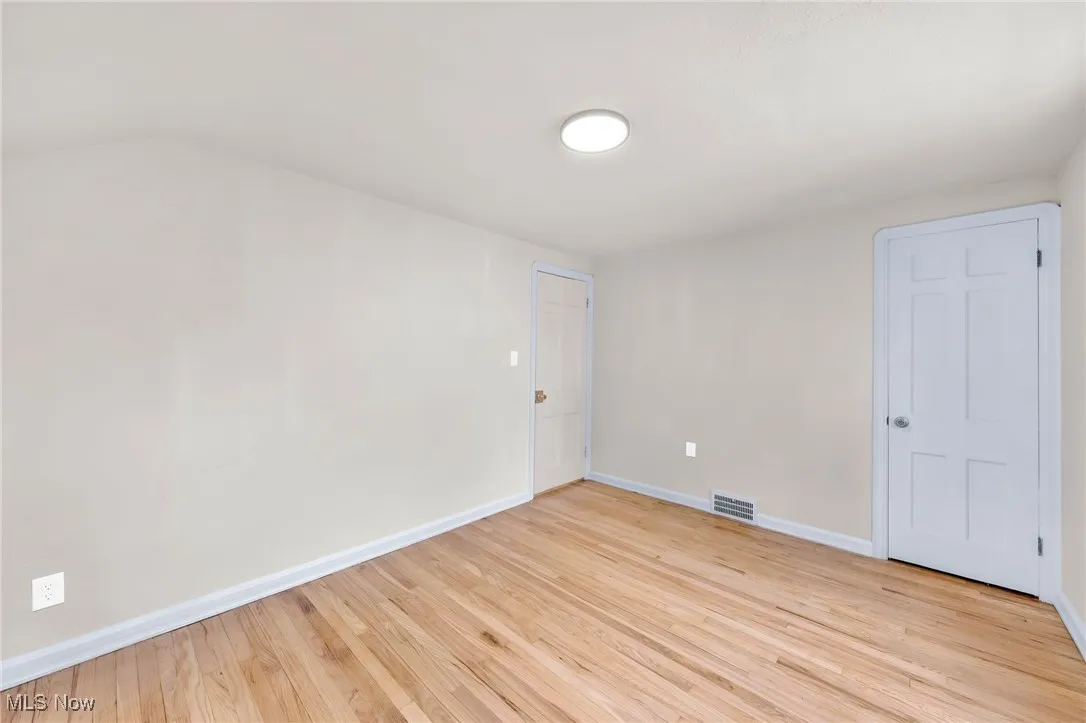 Unfurnished room with light wood-style floors and baseboards