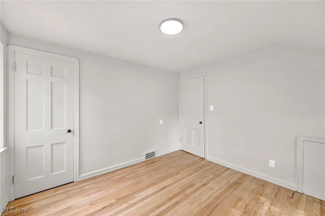 Spare room featuring wood finished floors and baseboards