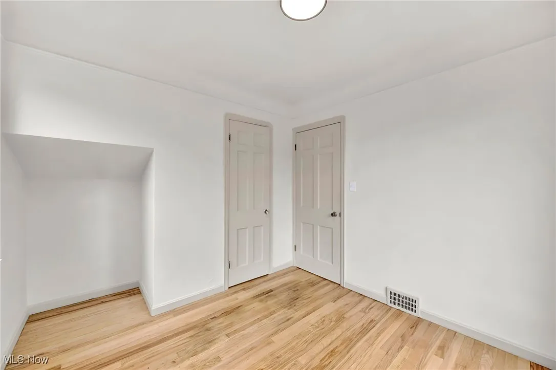 Spare room featuring wood finished floors and baseboards