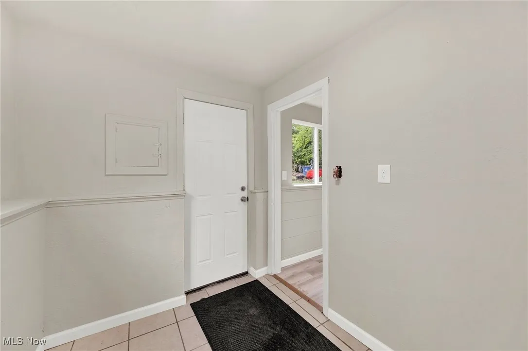 Foyer entrance with baseboards and light tile patterned floors