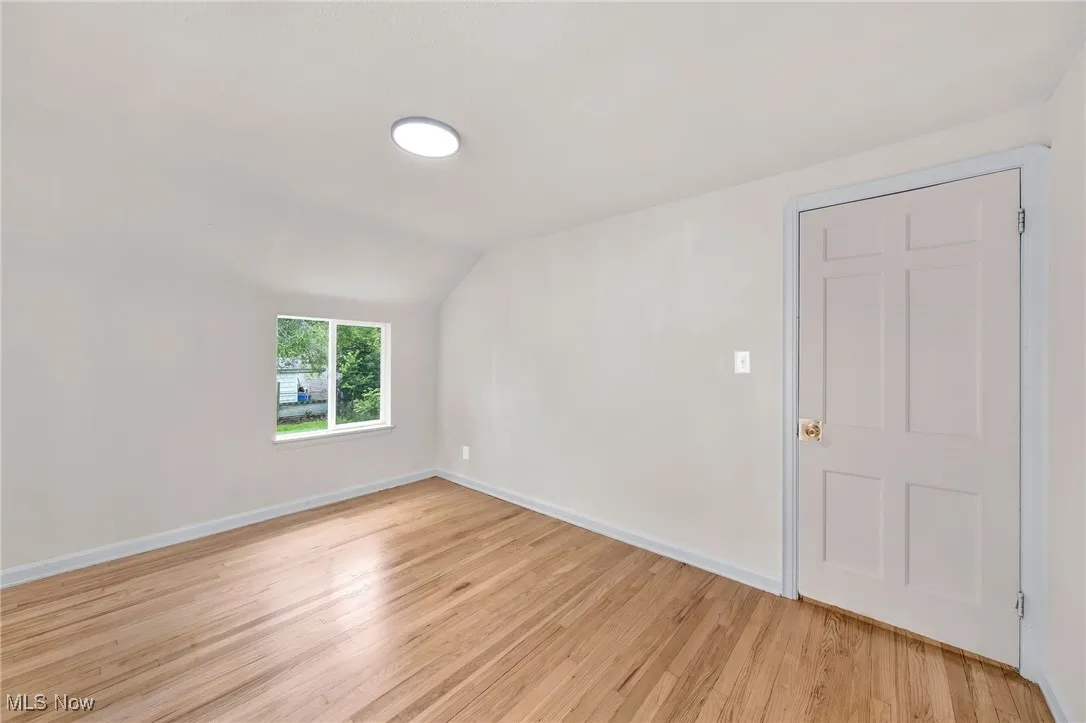 Bonus room with lofted ceiling and light wood finished floors