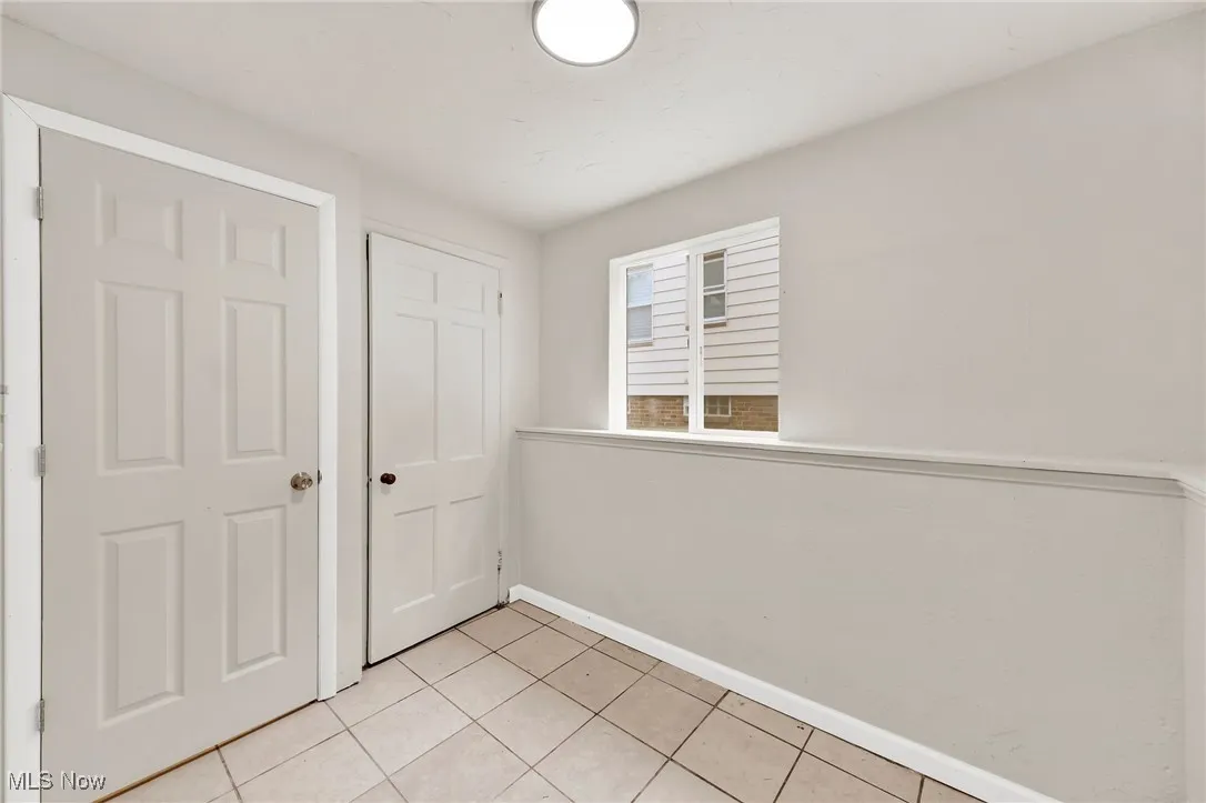 Unfurnished bedroom featuring light tile patterned floors and a closet
