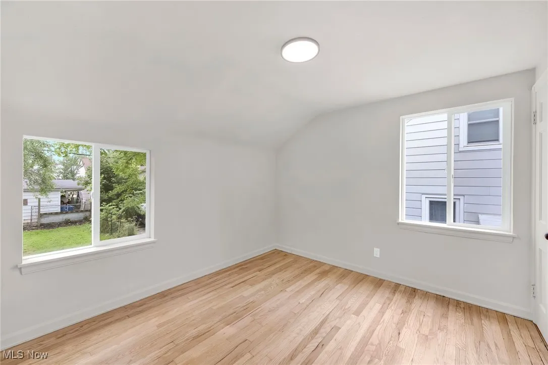 Additional living space with vaulted ceiling and wood finished floors
